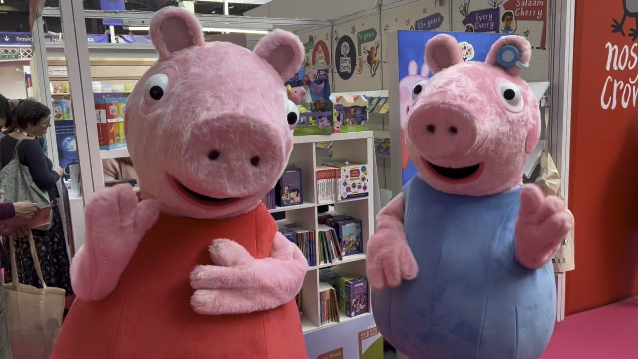 Peppa Pig and George costumes in front of a children's book stand at the London Book Fair